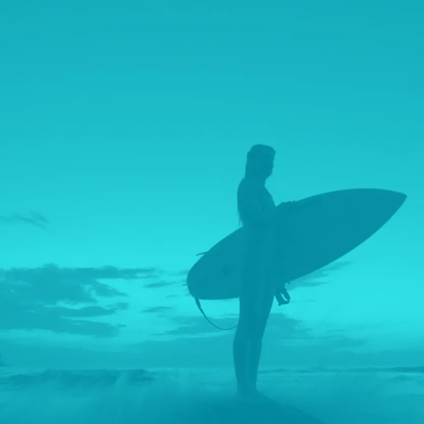 Petit BamBou campaign visual: a surfer silhouette at dusk in turquoise tones